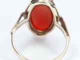 a close up of a ring with a red stone in it