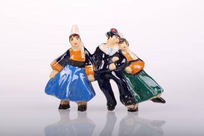 two figurines of a man and a woman sitting on a bench