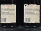 two bottles of wine sitting next to each other on a table