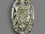 a silver spoon with a lion on it on a gray surface