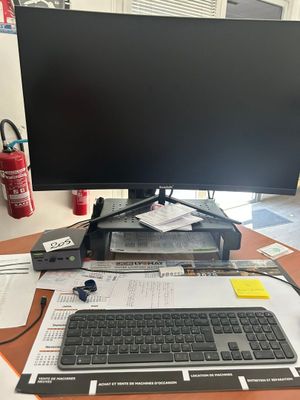 un ordinateur posé sur un bureau, avec un clavier et un écran