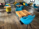 brightly colored chairs and tables in a restaurant with a brick wall