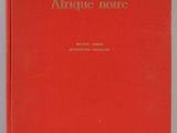 un livre rouge posé sur une table blanche
