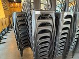 de nombreuses chaises empilées les unes sur les autres dans une pièce