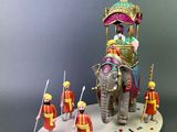 a figurine of an elephant with people riding on it