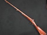 un vieux fusil avec une crosse et un canon en bois