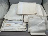 beaucoup de linge de maison dans une valise posée par terre