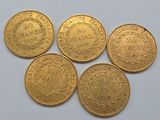 five gold coins with the names of different countries on them