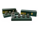 a set of three glass salt and pepper shakers in a green box