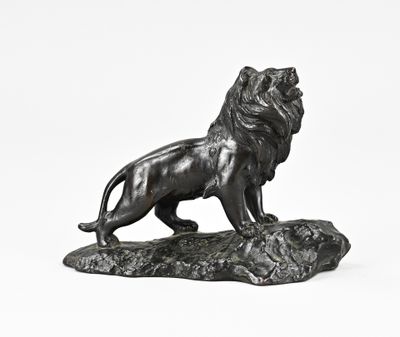 statue en bronze représentant un lion debout sur un rocher, sur fond blanc
