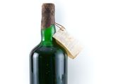 green glass bottle with cork and label on white background