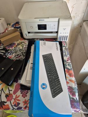 une imprimante posée sur une table, à côté d'un clavier