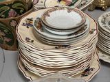 several plates and bowls are stacked on a table with a glass container