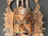 an image of a wooden mask on a black surface