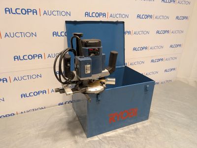a blue box with a machine on top of it in front of a wall