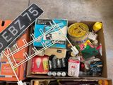 a cardboard box filled with assorted items and a sign