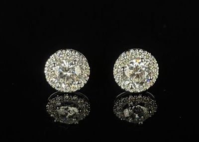 une paire de boucles d'oreilles en diamant posées sur une surface noire