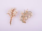 une paire de broches en perles et en or sur fond blanc