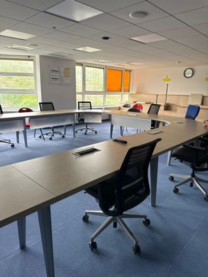 des tables et des chaises dans une pièce où il y a une horloge accrochée au mur