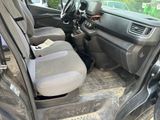 the interior of a car with the door open and the driver ' s seat down