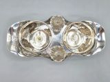 a close up of a silver plate with a flower design on it