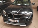 un SUV BMW noir garé dans un parking couvert