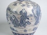 a blue and white vase with a picture of animals on it