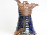 a blue and brown vase with a bird on it