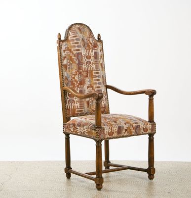 an old wooden chair with a patterned upholstered seat