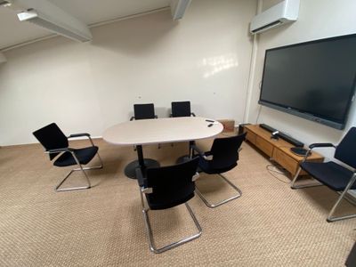 une photo d'une salle de réunion avec des chaises et un téléviseur à écran plat
