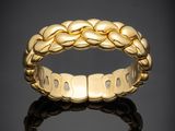 une bague tressée en or jaune sur un fond noir
