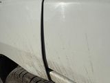 a white truck that has a flat tire on the side of the road
