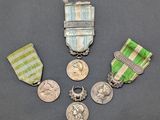 trois médailles et une médaille posée sur une surface grise