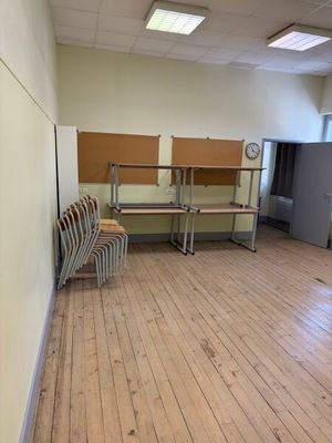 une pièce avec plusieurs chaises et un mur sur lequel est accrochée une horloge