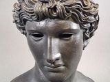 a close up of a statue of a man with curly hair