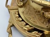 a gold clock sitting on top of a white table
