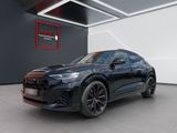 un SUV Audi noir garé dans un showroom, à côté d'un panneau rouge