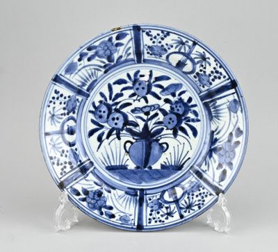 assiette bleue et blanche sur laquelle est représenté un vase de fleurs