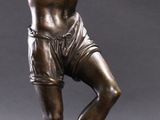 bronze statue of a man in a boxing stance on a pedestal
