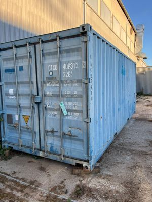 a blue shipping container sitting in front of a building
