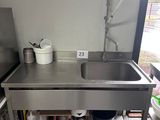 a stainless steel sink in a kitchen with a metal faucet