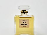a bottle of perfume sitting on top of a white surface