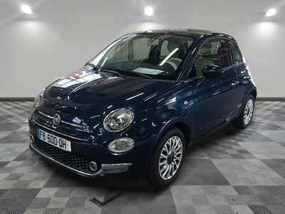 la petite voiture bleue est garée sur un carrelage à carreaux
