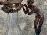 a glass vase with a figurine on top of it