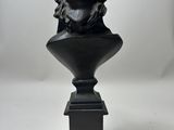 bronze bust of a man with a hat on a pedestal