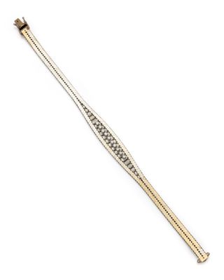 un bracelet en or et en argent serti de diamants sur fond blanc
