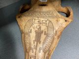 an old wooden vase with a design on it in a glass case