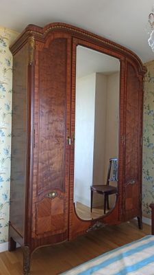 une photo d'une chambre à coucher avec une grande armoire en bois