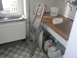 une échelle appuyée contre le mur dans une petite cuisine