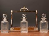 three clear glass bottles sitting on top of a wooden table